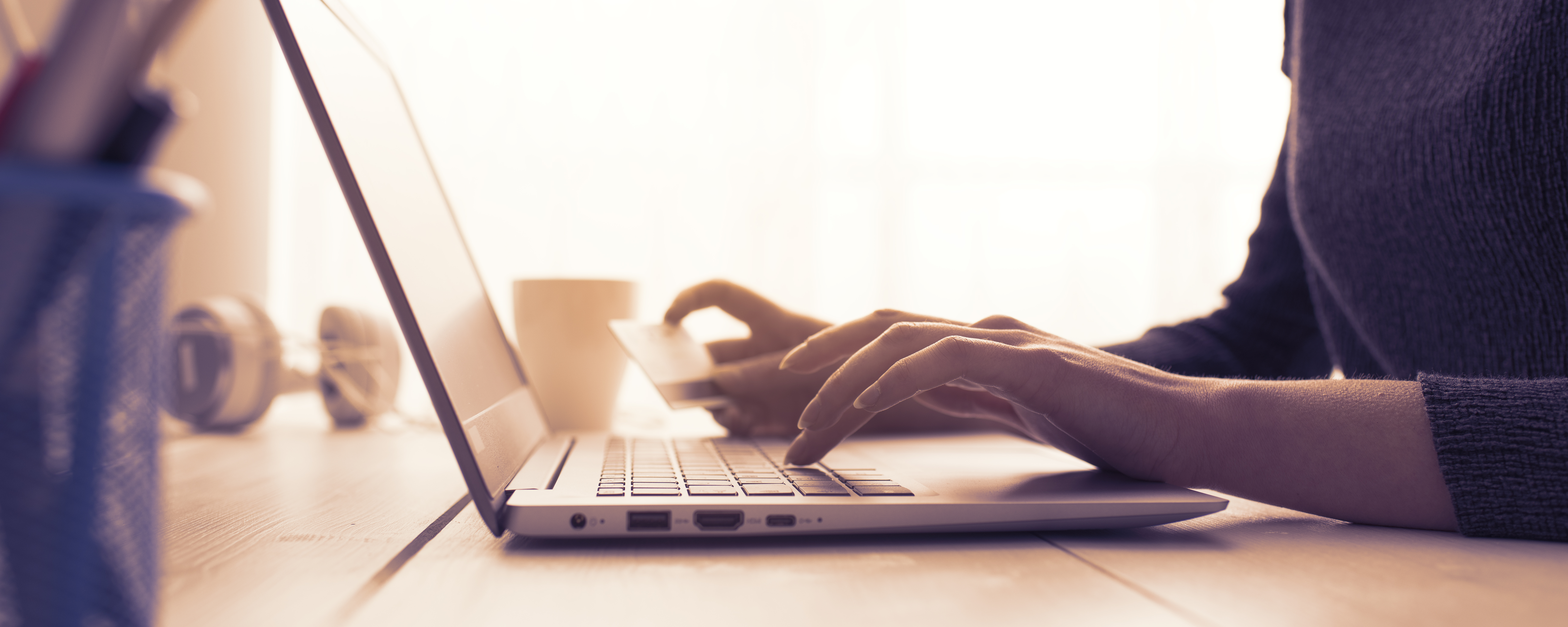 Person holding credit card and typing on laptop