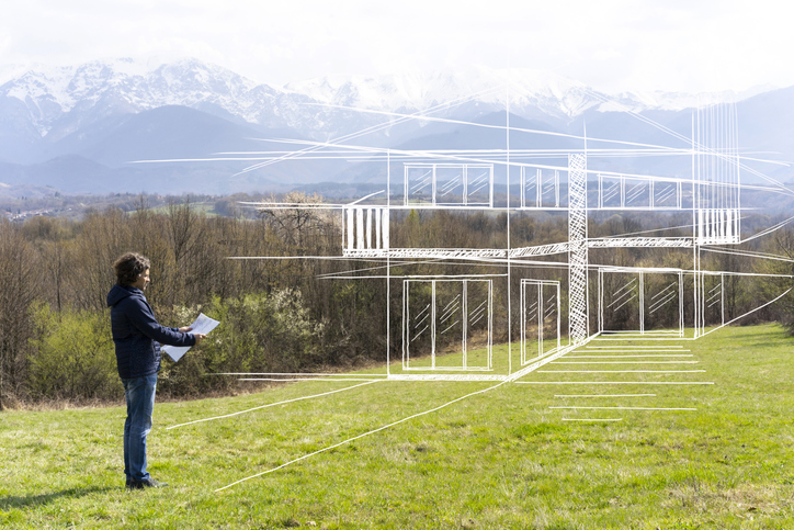 Person looking at house blueprint outside